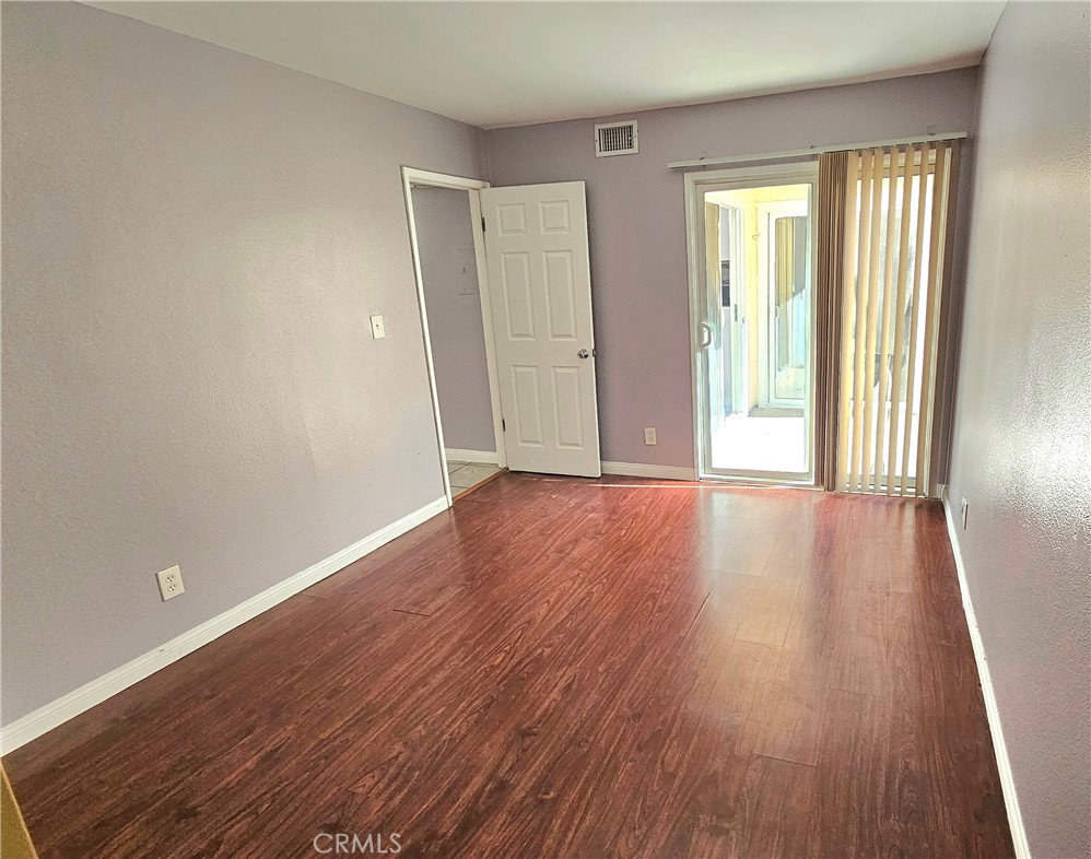7641 Reseda Boulevard, Unit 87 Reseda, CA 91335 - Photo 24 of 37 an empty room with wooden floor and windows