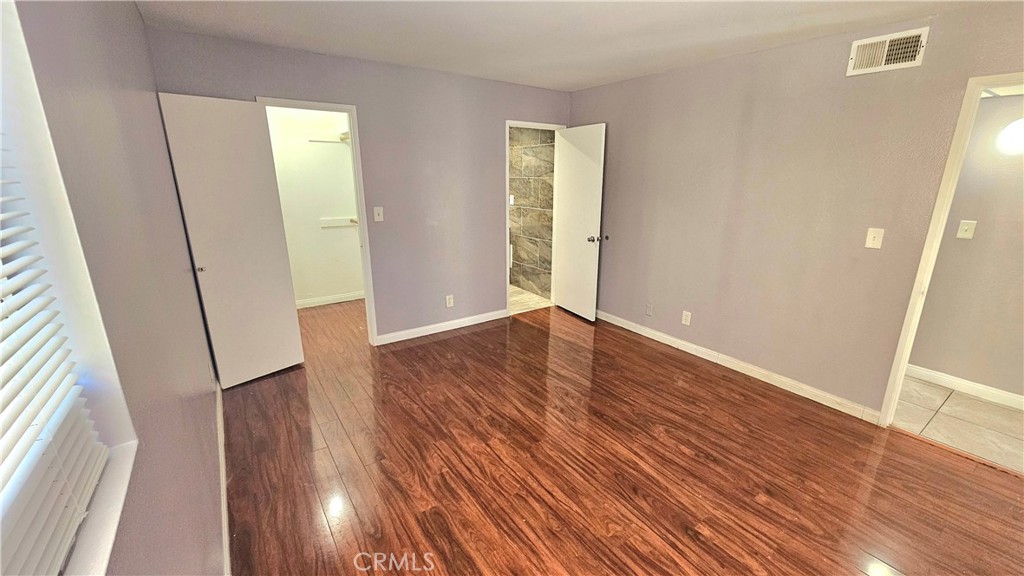 7641 Reseda Boulevard, Unit 87 Reseda, CA 91335 - Photo 25 of 37 an empty room with wooden floor and entrance