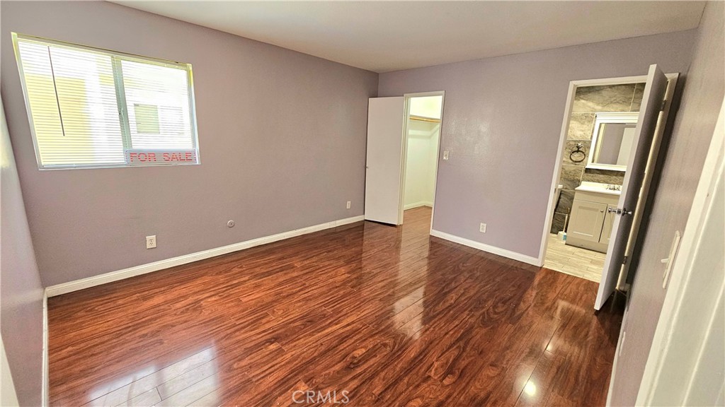 7641 Reseda Boulevard, Unit 87 Reseda, CA 91335 - Photo 26 of 37 a view of an empty room with wooden floor and a window