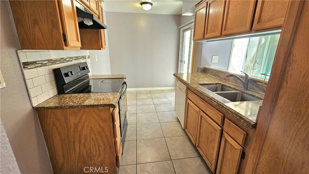 7641 Reseda Boulevard, Unit 87 Reseda, CA 91335 - Photo 10 of 37 a kitchen with granite countertop a sink and a stove