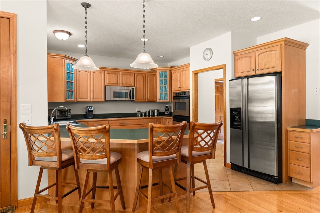 59 St Germain Road Hampden, MA 01036 - Photo 22 of 42 a kitchen with stainless steel appliances granite countertop a refrigerator a stove a kitchen island with a dining table and chairs