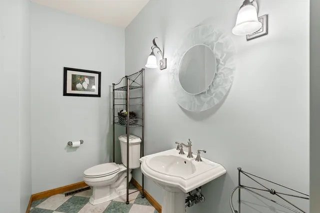 a bathroom with a toilet a sink and mirror