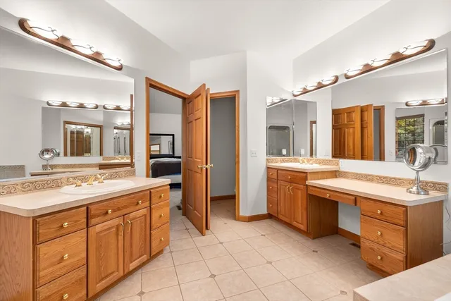 a spacious bathroom with a granite countertop sink mirror and