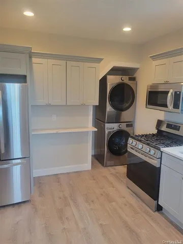 a kitchen with granite countertop a sink stainless steel appliances and white cabinets