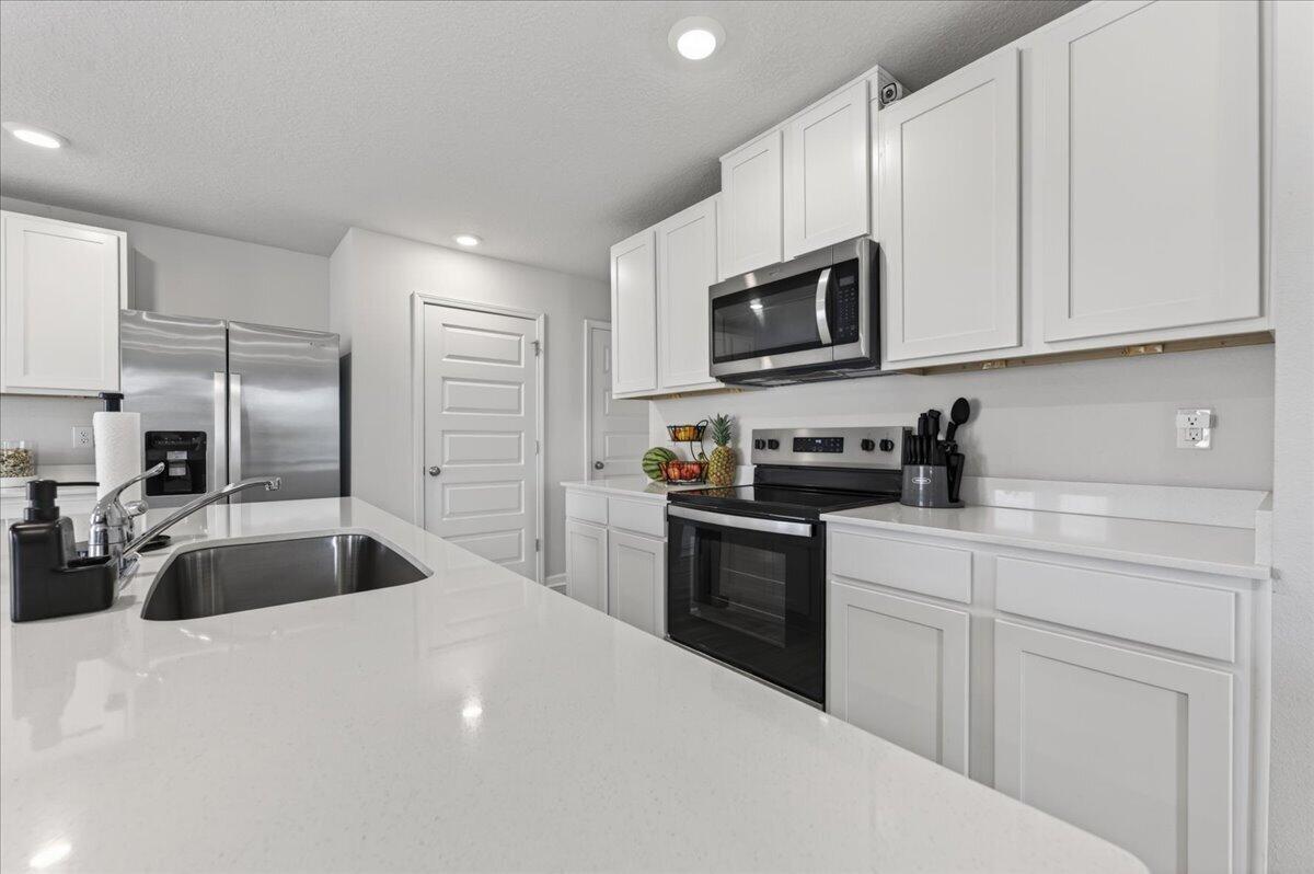 2808 Tallgrass Court Crestview, FL 32536 - Photo 13 of 49 a kitchen with granite countertop a sink and stainless steel appliances