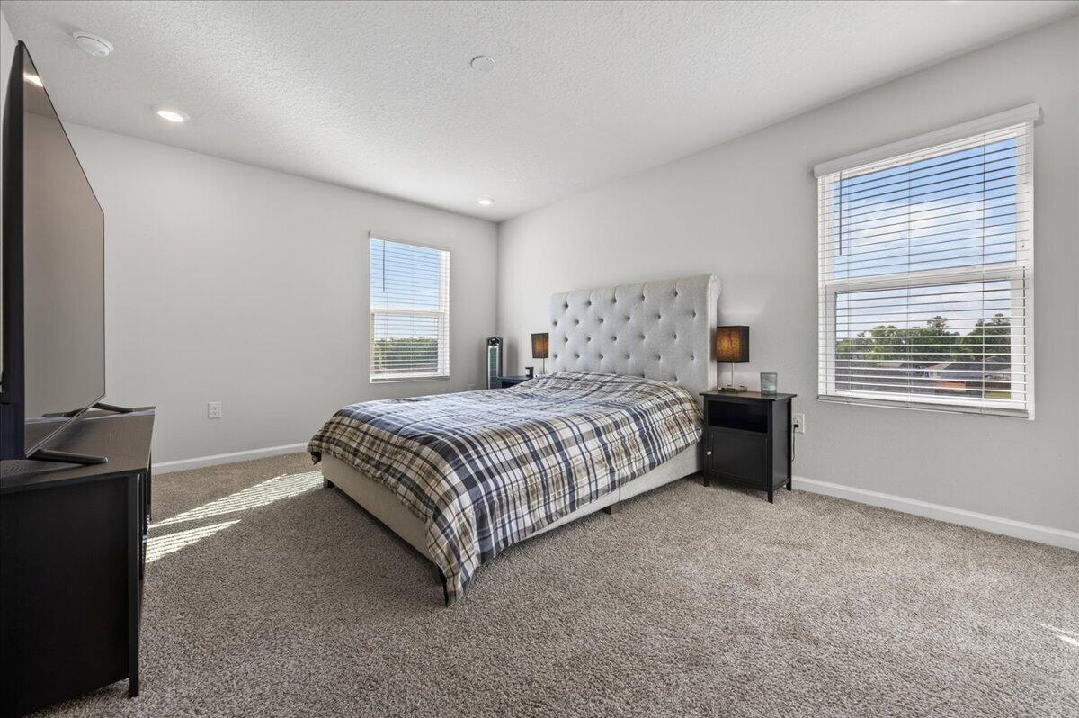 2808 Tallgrass Court Crestview, FL 32536 - Photo 23 of 49 a bedroom with a bed and a flat tv screen on a dresser