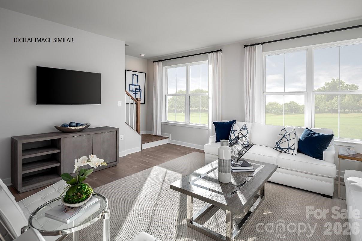 2287 Flicker Road, Unit 1050A Indian Land, SC 29707 - Photo 4 of 13 a living room with furniture a flat screen tv and a floor to ceiling window