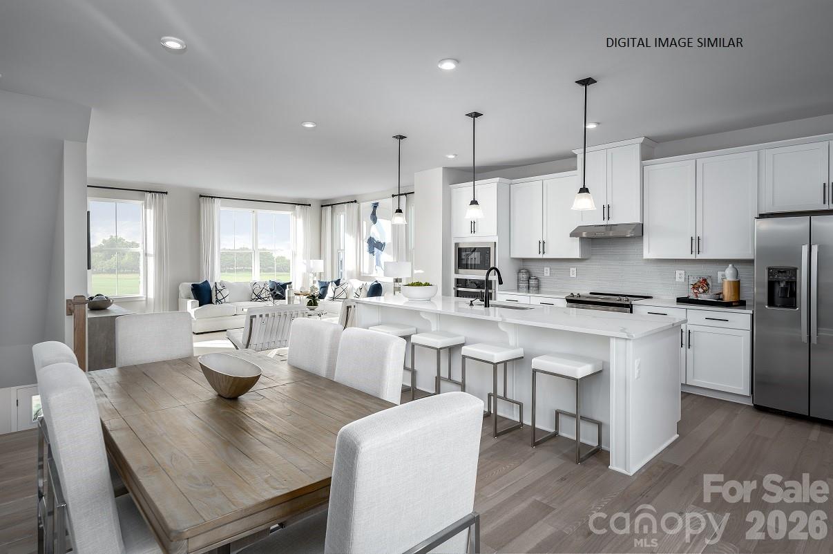 2287 Flicker Road, Unit 1050A Indian Land, SC 29707 - Photo 5 of 13 a large kitchen with white cabinets and stainless steel appliances