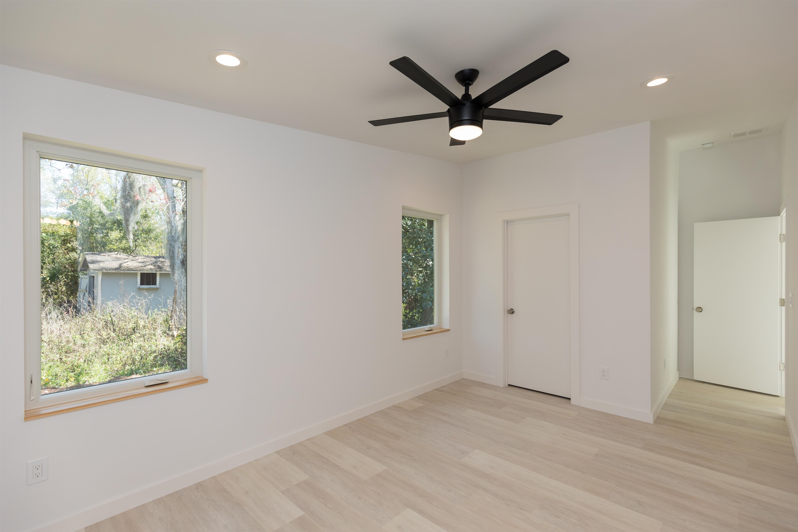 561 Live Oak Street St. Augustine, FL 32084 - Photo 22 of 30 a view of a big room with wooden floor a ceiling fan and windows
