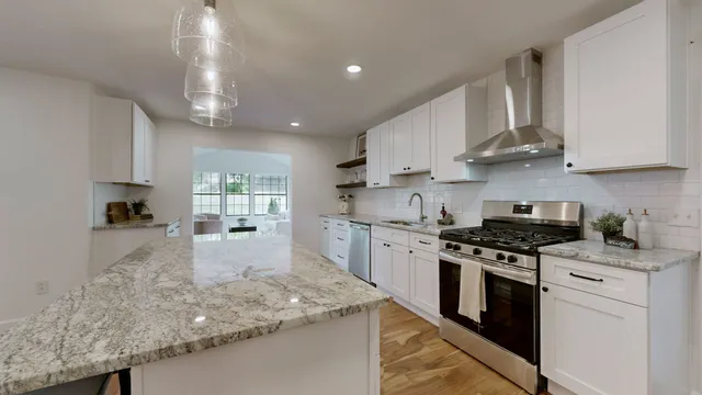 a kitchen with stainless steel appliances granite countertop a sink stove and cabinets