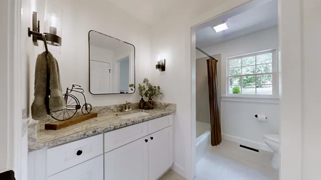 a bathroom with a granite countertop sink and a mirror