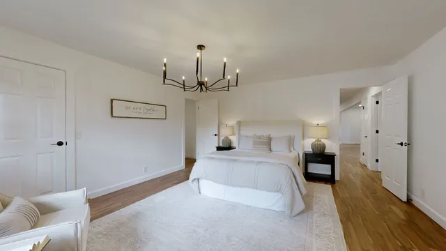 a bedroom with a bed and a chandelier