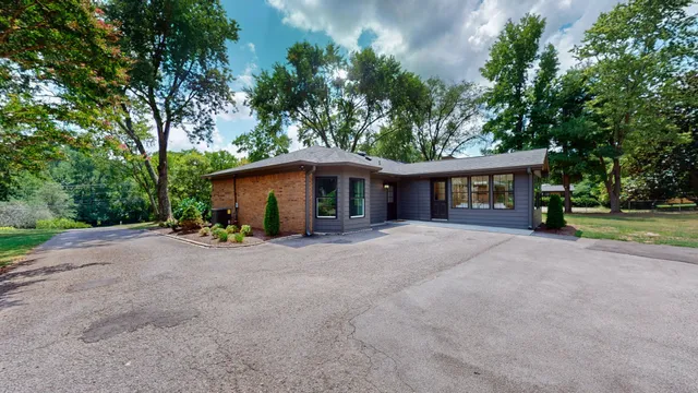 a view of a house with a yard and potted plants