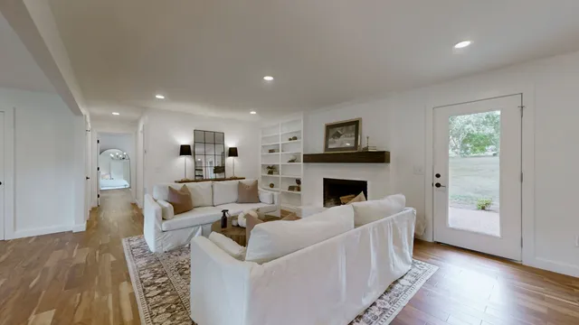 a living room with furniture a fireplace and a wooden floor
