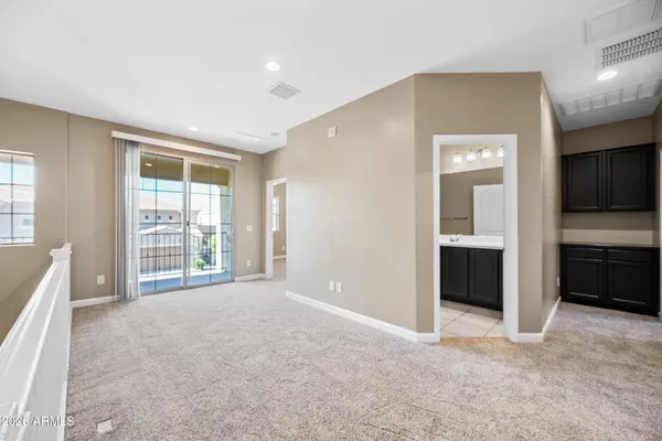 a view of an empty room with a window and a kitchen