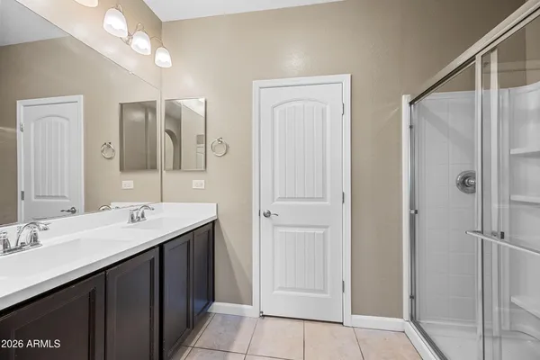 a bathroom with a double vanity sink mirror and shower