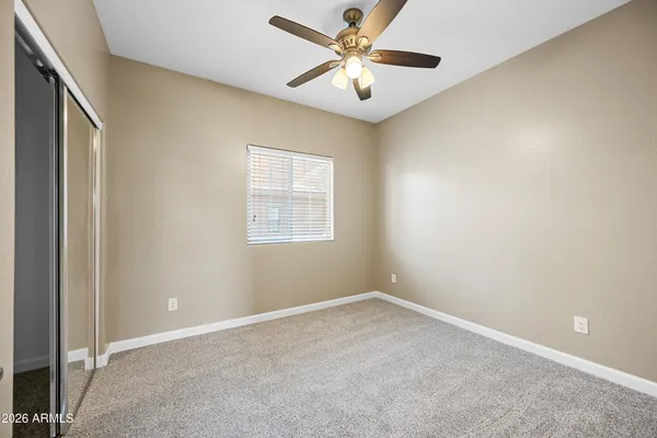 an empty room with a window and a fan