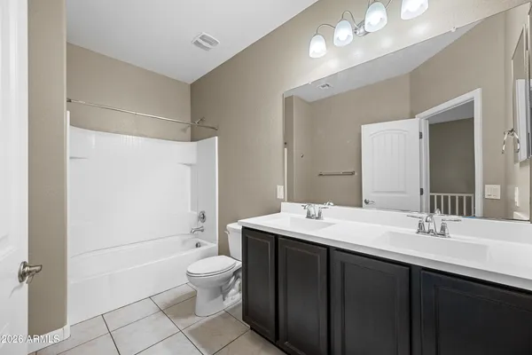 a bathroom with a double vanity sink toilet mirror and shower