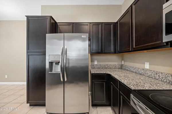 a kitchen with granite countertop a refrigerator and a sink