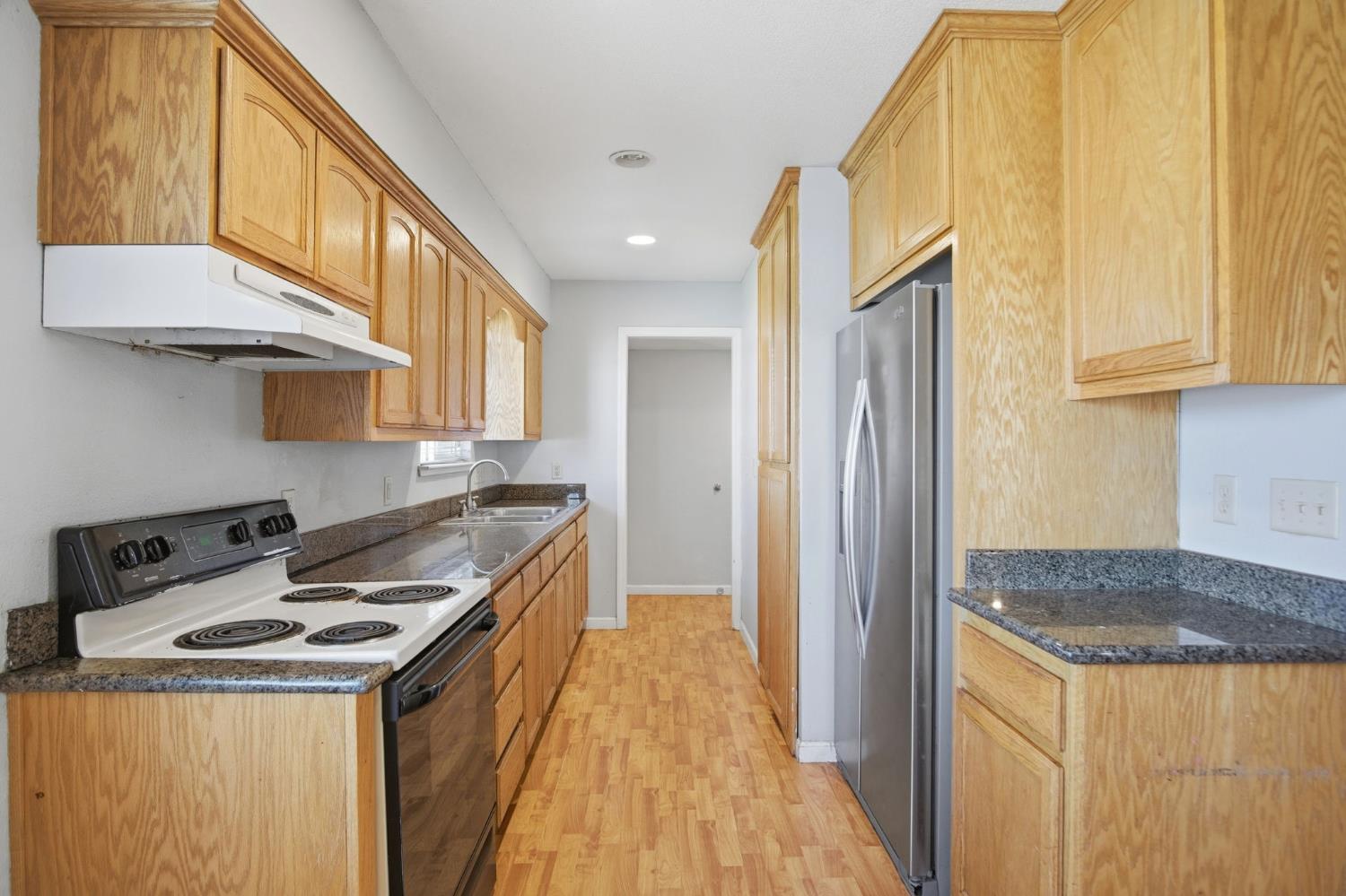 1409 Stonum Road Modesto, CA 95351 - Photo 20 of 40 a kitchen with a sink a stove and a refrigerator