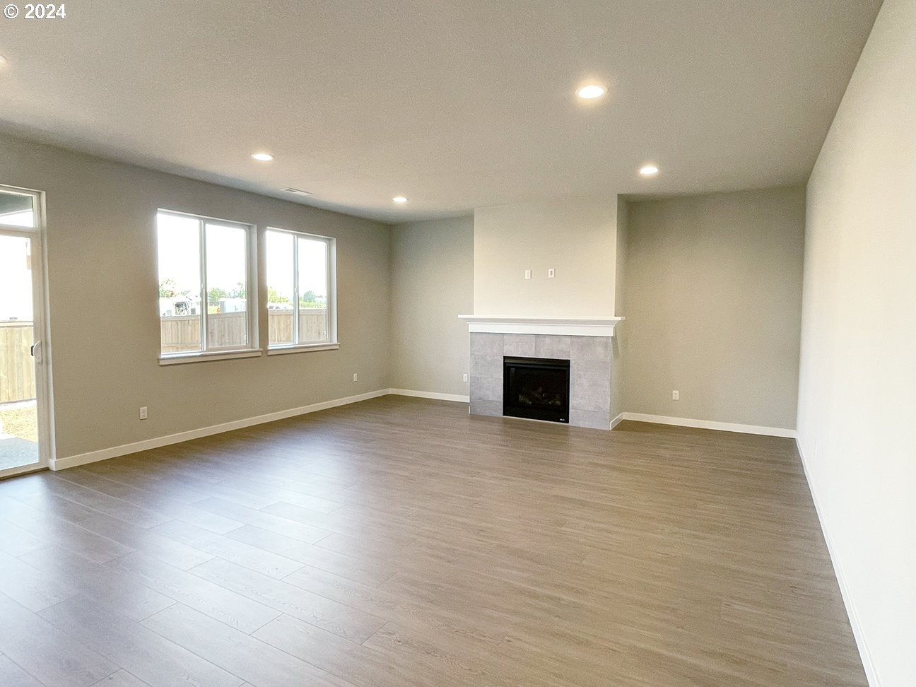 8720 North 3rd Street, Unit 57 Ridgefield, WA 98642 - Photo 10 of 24 an empty room with wooden floor fireplace and windows