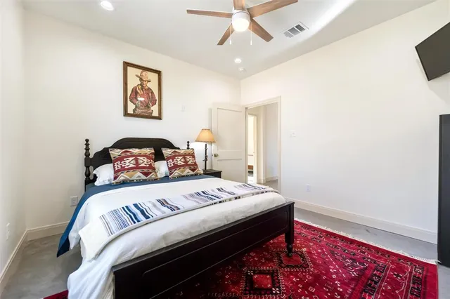 a bedroom with a bed and a lamp on a dresser