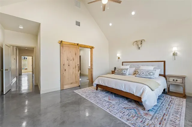 a spacious bedroom with a bed and a lamp