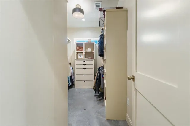 a view of walk in closet with clothes and shoes