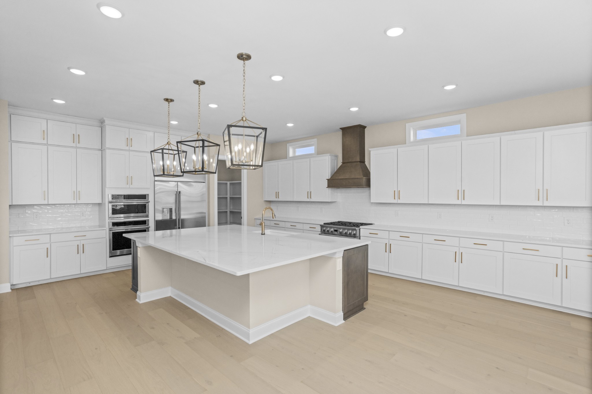 5955 Hunt Vly Drive Spring Hill, TN 37174 - Photo 16 of 59 a large white kitchen with kitchen island a sink a stove a refrigerator and white cabinets