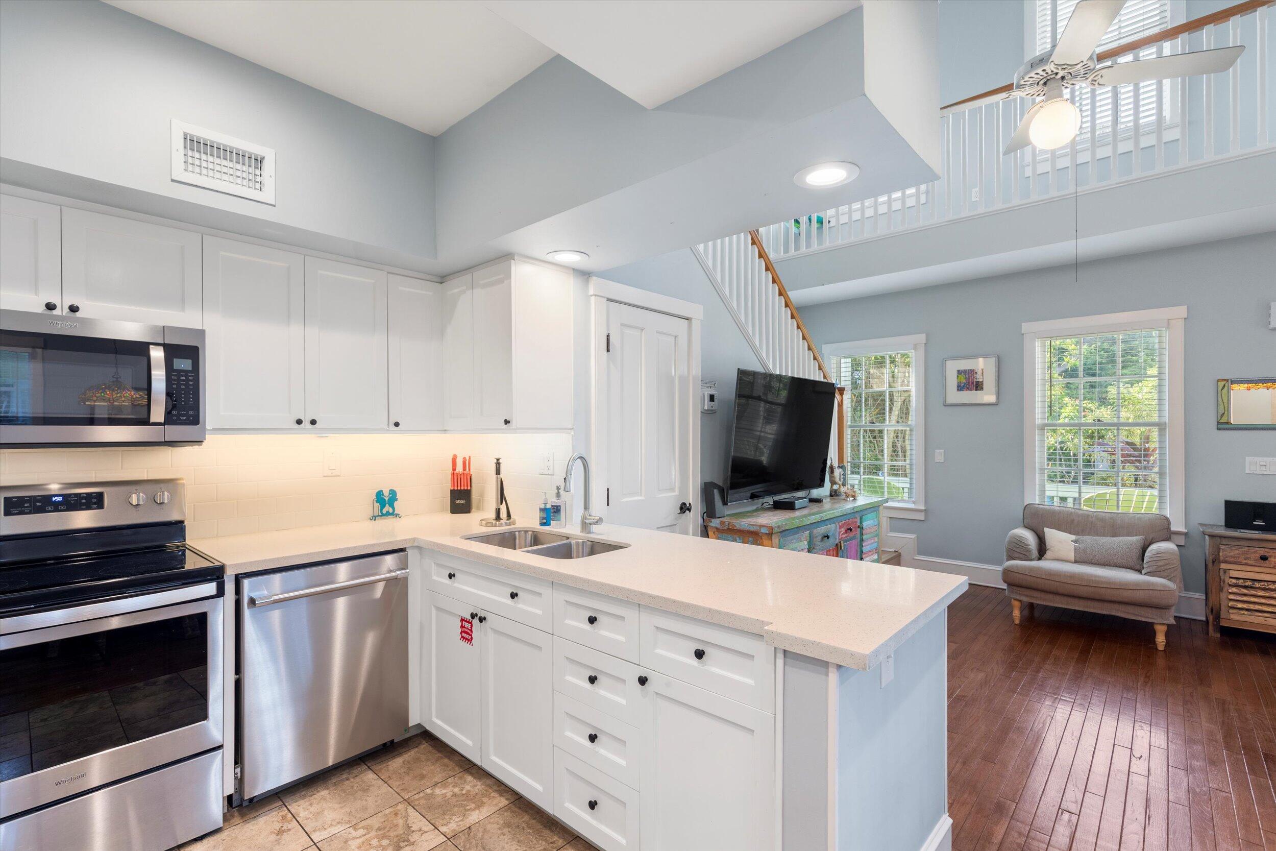 606 Truman Avenue, Unit 7 Key West, FL 33040 - Photo 12 of 49 a kitchen with a sink stove and cabinets
