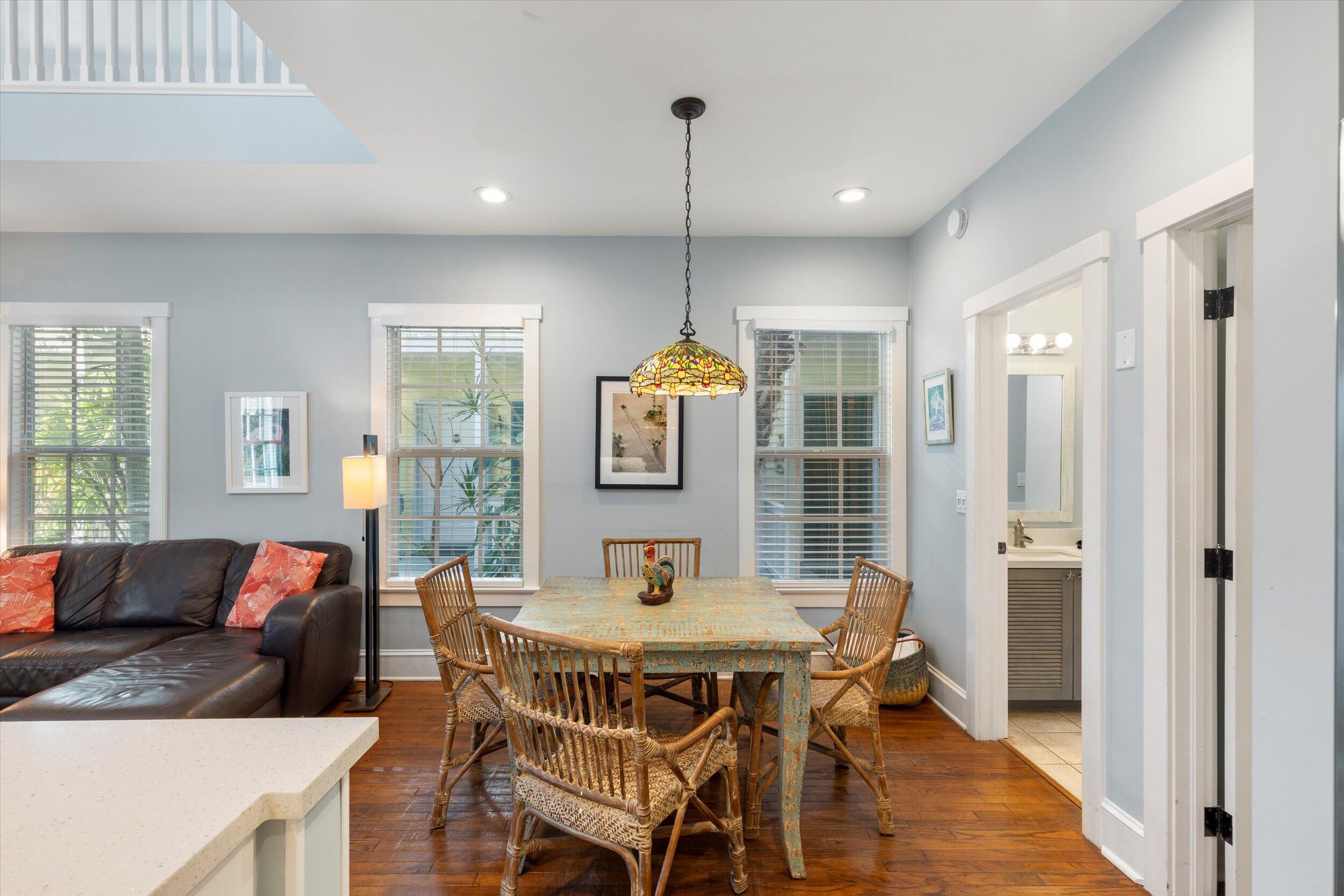 606 Truman Avenue, Unit 7 Key West, FL 33040 - Photo 17 of 49 a living room with furniture a dining table and a chandelier