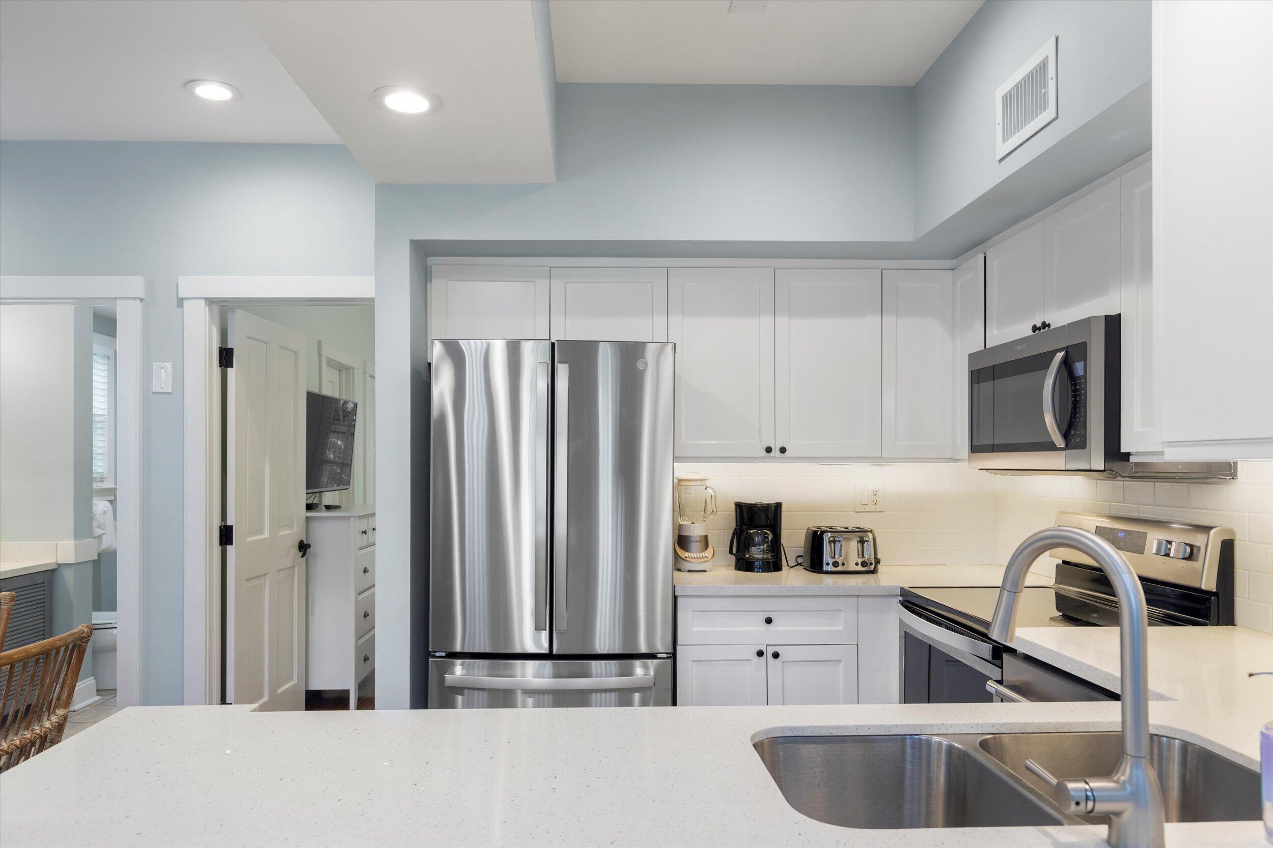 606 Truman Avenue, Unit 7 Key West, FL 33040 - Photo 18 of 49 a kitchen with stainless steel appliances granite countertop a refrigerator sink and stove