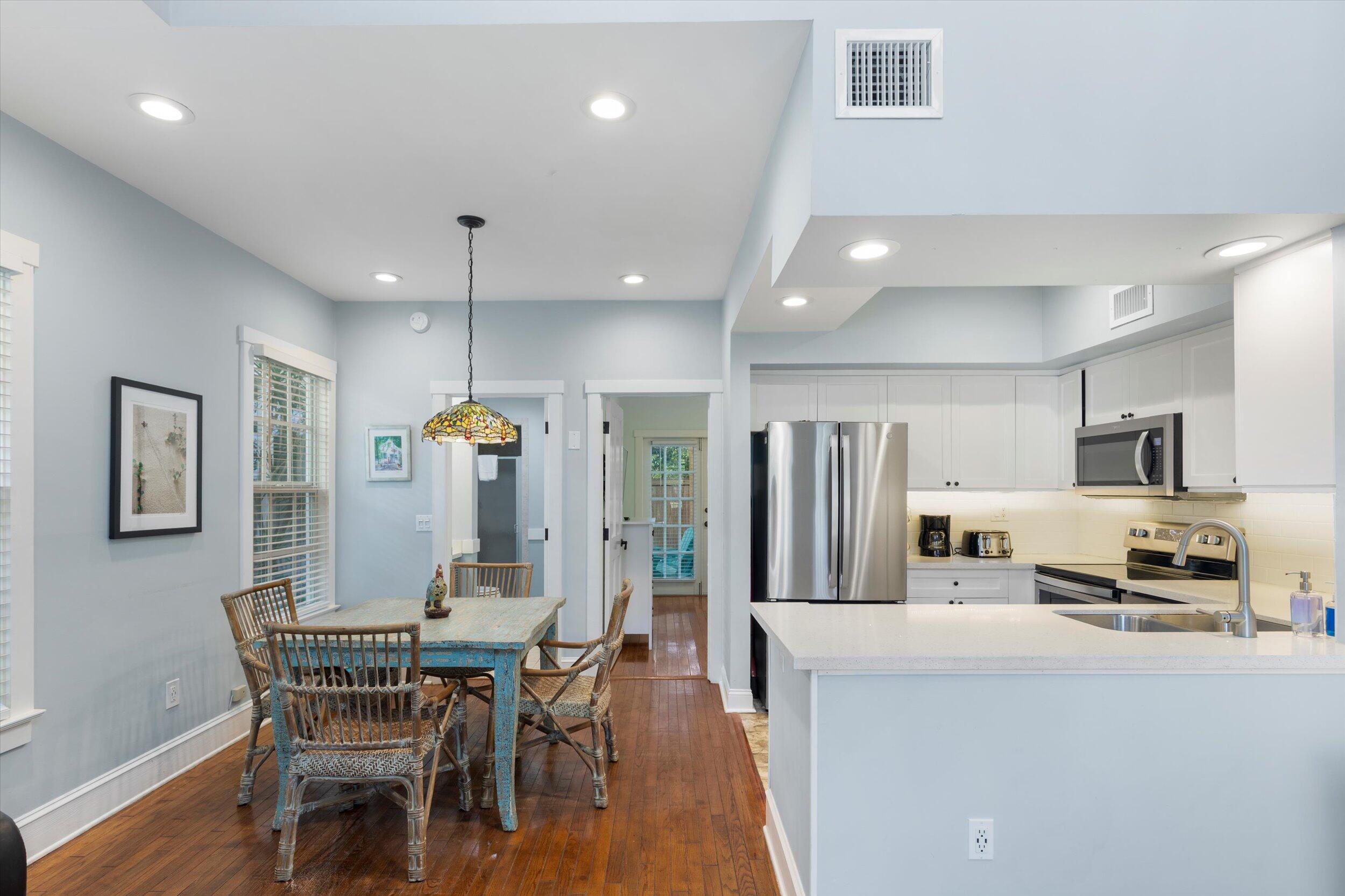 606 Truman Avenue, Unit 7 Key West, FL 33040 - Photo 20 of 49 a kitchen with stainless steel appliances granite countertop a stove a refrigerator a kitchen island a dining table and chairs