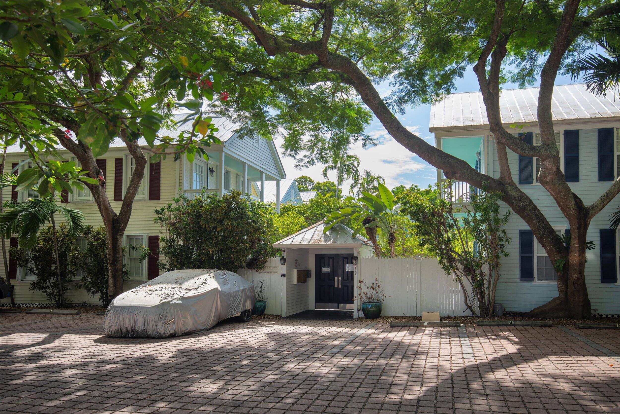 606 Truman Avenue, Unit 7 Key West, FL 33040 - Photo 2 of 49 a white house that has a tree in front of it