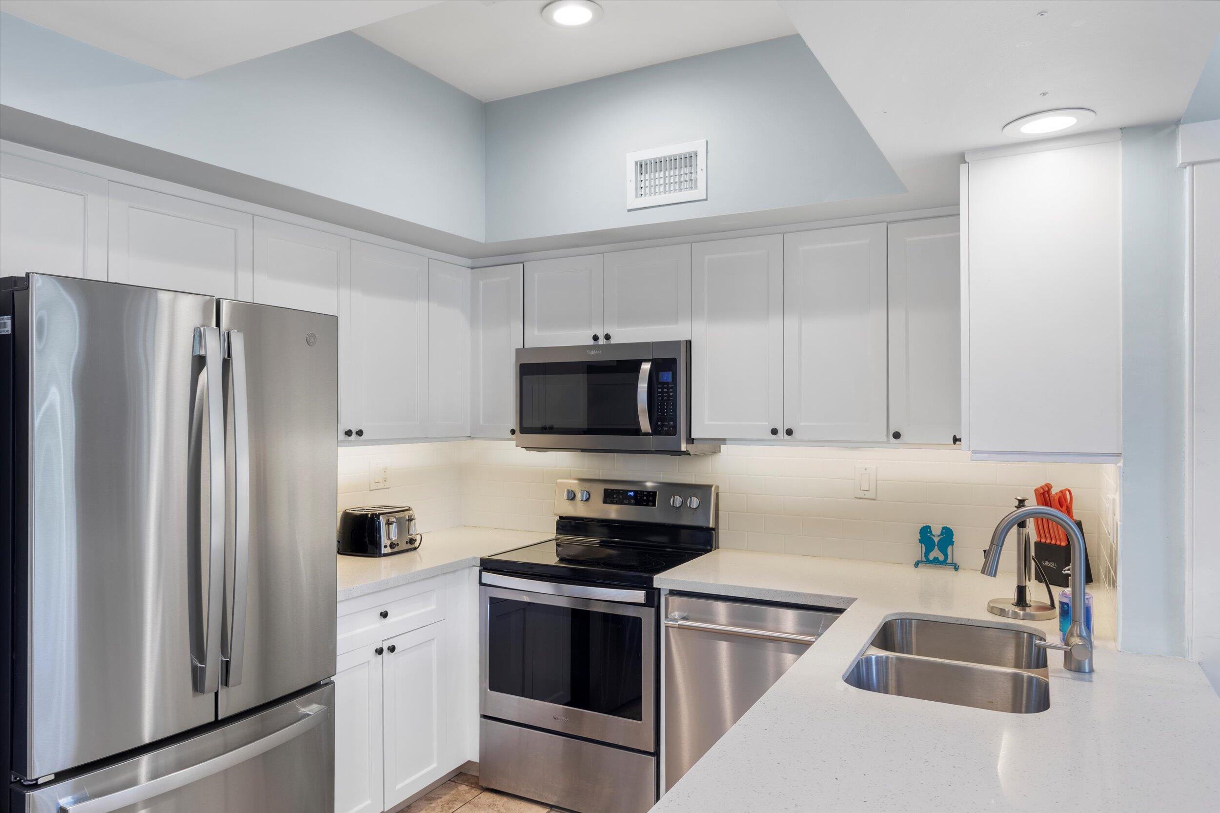 606 Truman Avenue, Unit 7 Key West, FL 33040 - Photo 10 of 49 a kitchen with stainless steel appliances granite countertop a refrigerator sink and stove