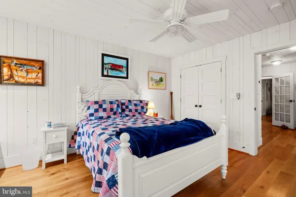 a bedroom with a bed and painting on the wall