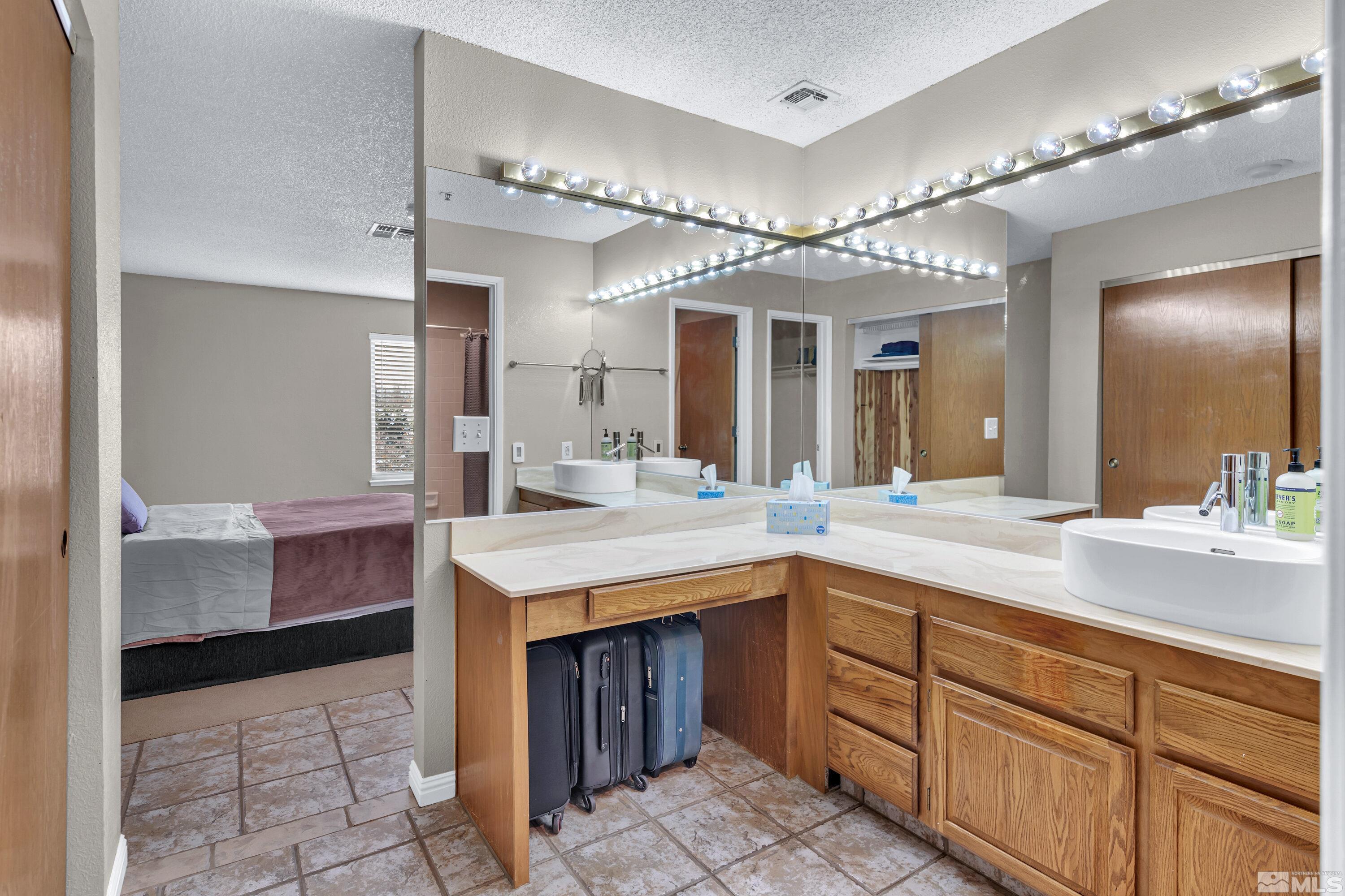 3095 Lakeside Drive, Unit 304 Reno, NV 89509 - Photo 18 of 38 a spacious bathroom with a granite countertop sink a mirror and a