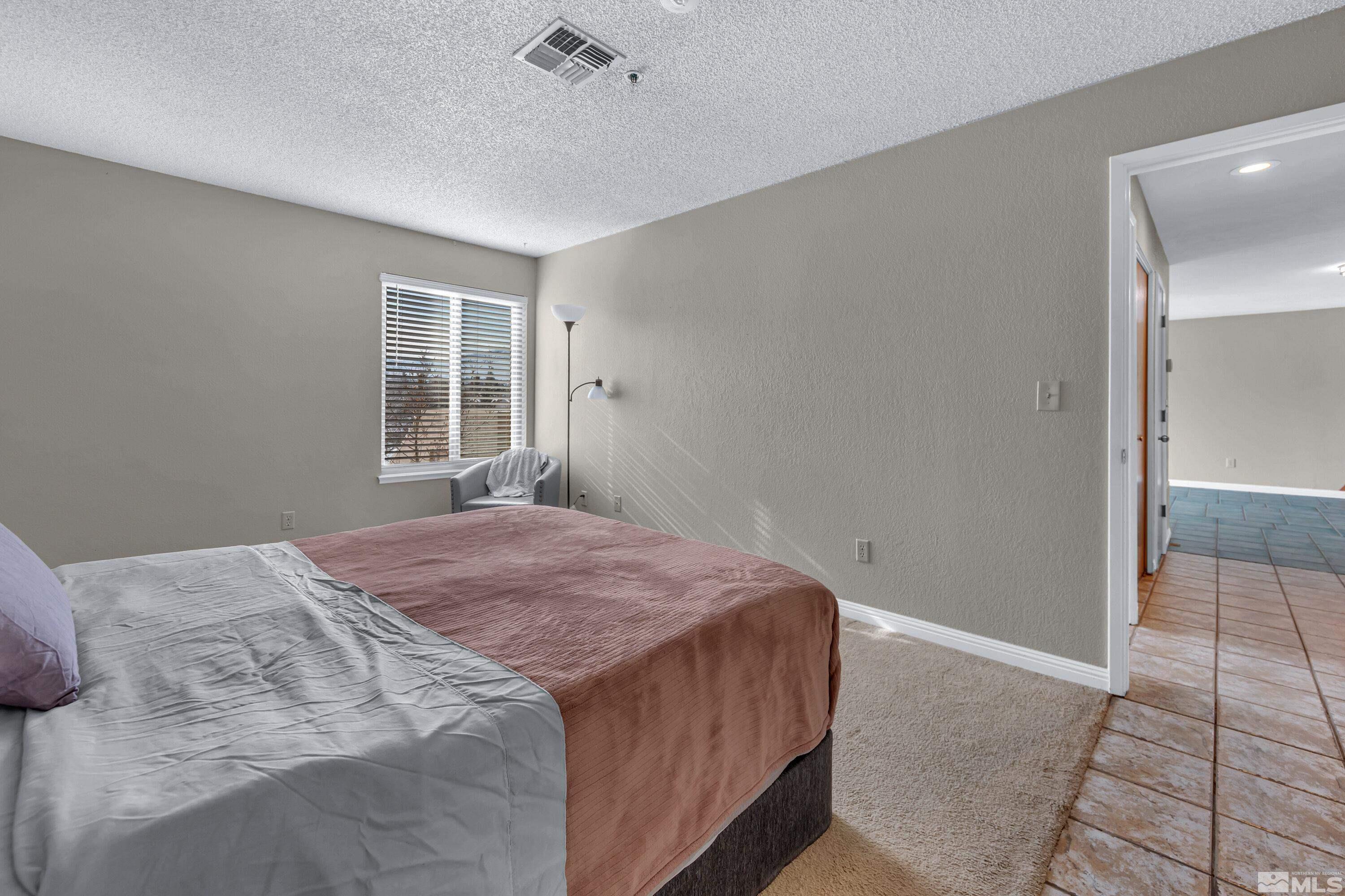 3095 Lakeside Drive, Unit 304 Reno, NV 89509 - Photo 20 of 38 a bedroom with a bed and a window