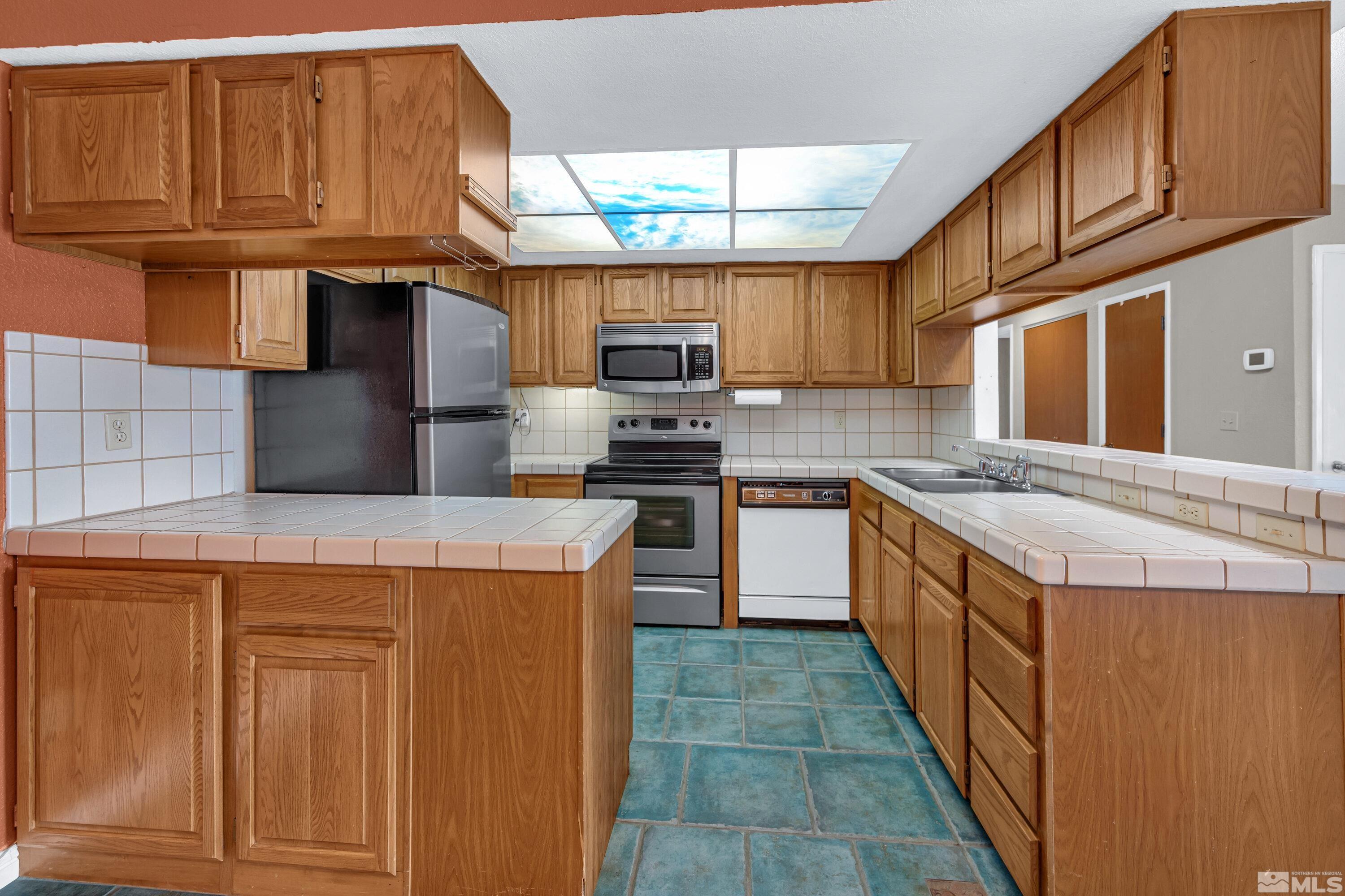 3095 Lakeside Drive, Unit 304 Reno, NV 89509 - Photo 5 of 38 a kitchen with stainless steel appliances granite countertop a stove and a refrigerator