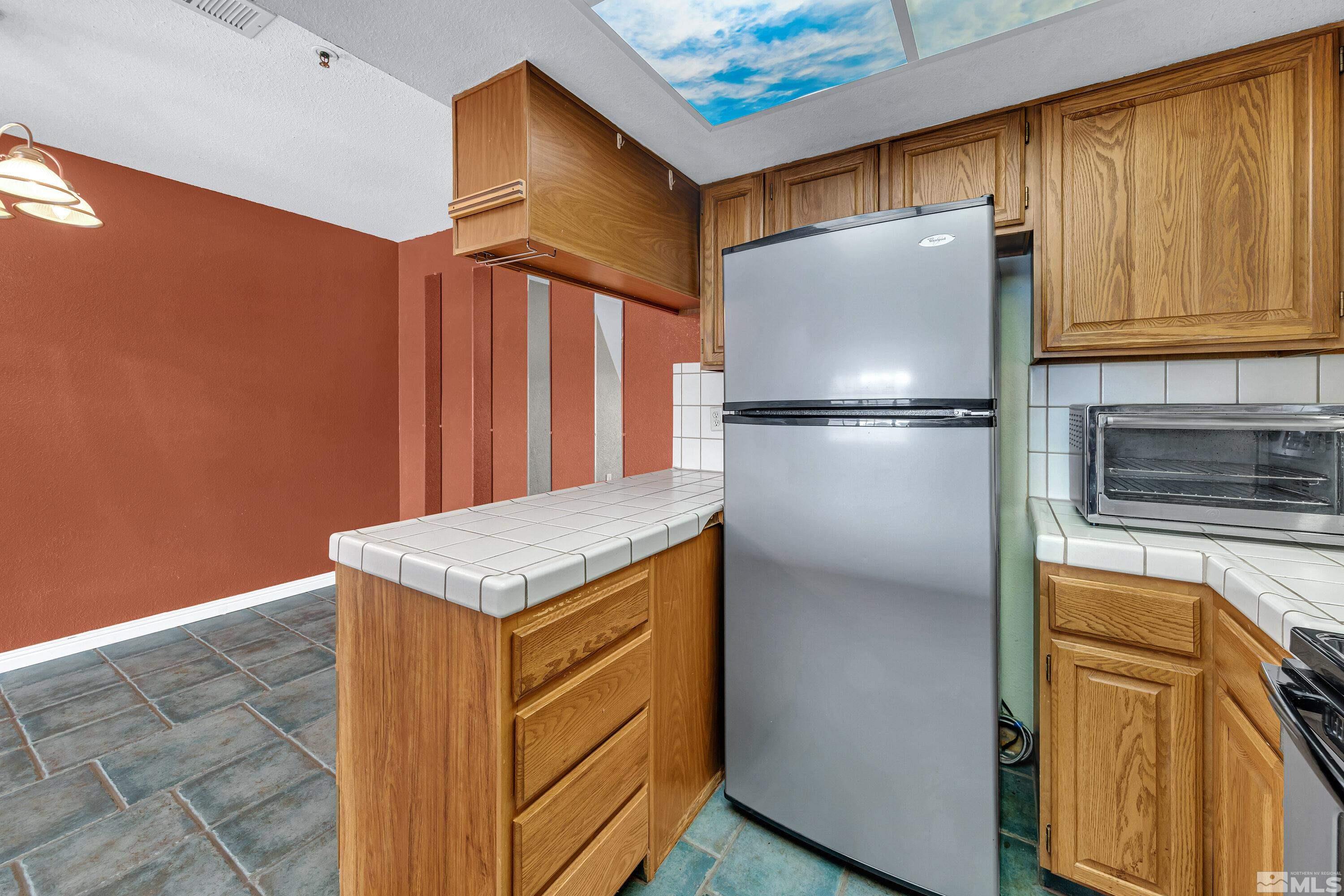 3095 Lakeside Drive, Unit 304 Reno, NV 89509 - Photo 7 of 38 a kitchen with stainless steel appliances granite countertop a refrigerator a stove and a sink with cabinets