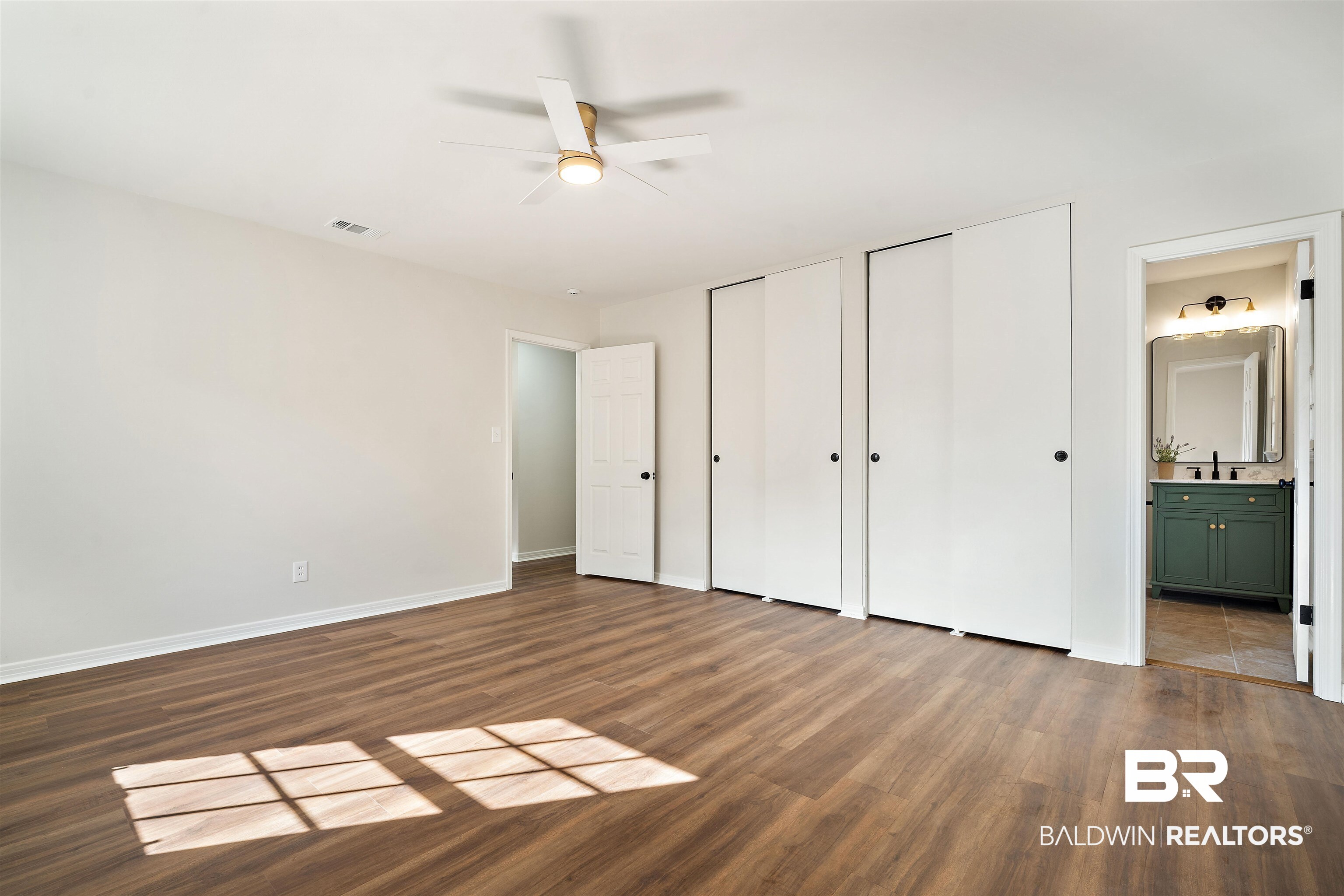 860 Montfort Road South Mobile, AL 36608 - Photo 16 of 27 Unfurnished bedroom with multiple closets, dark wood-style flooring, ensuite bath, and ceiling fan