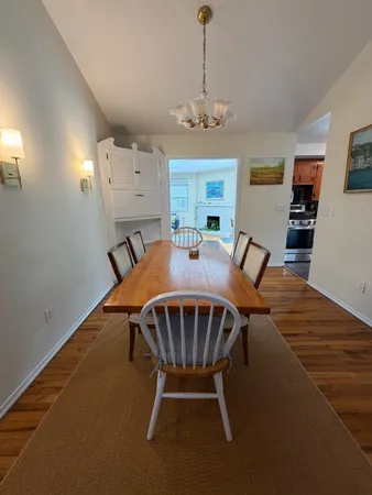 a view of a dining room with furniture a chandelier and wooden floor