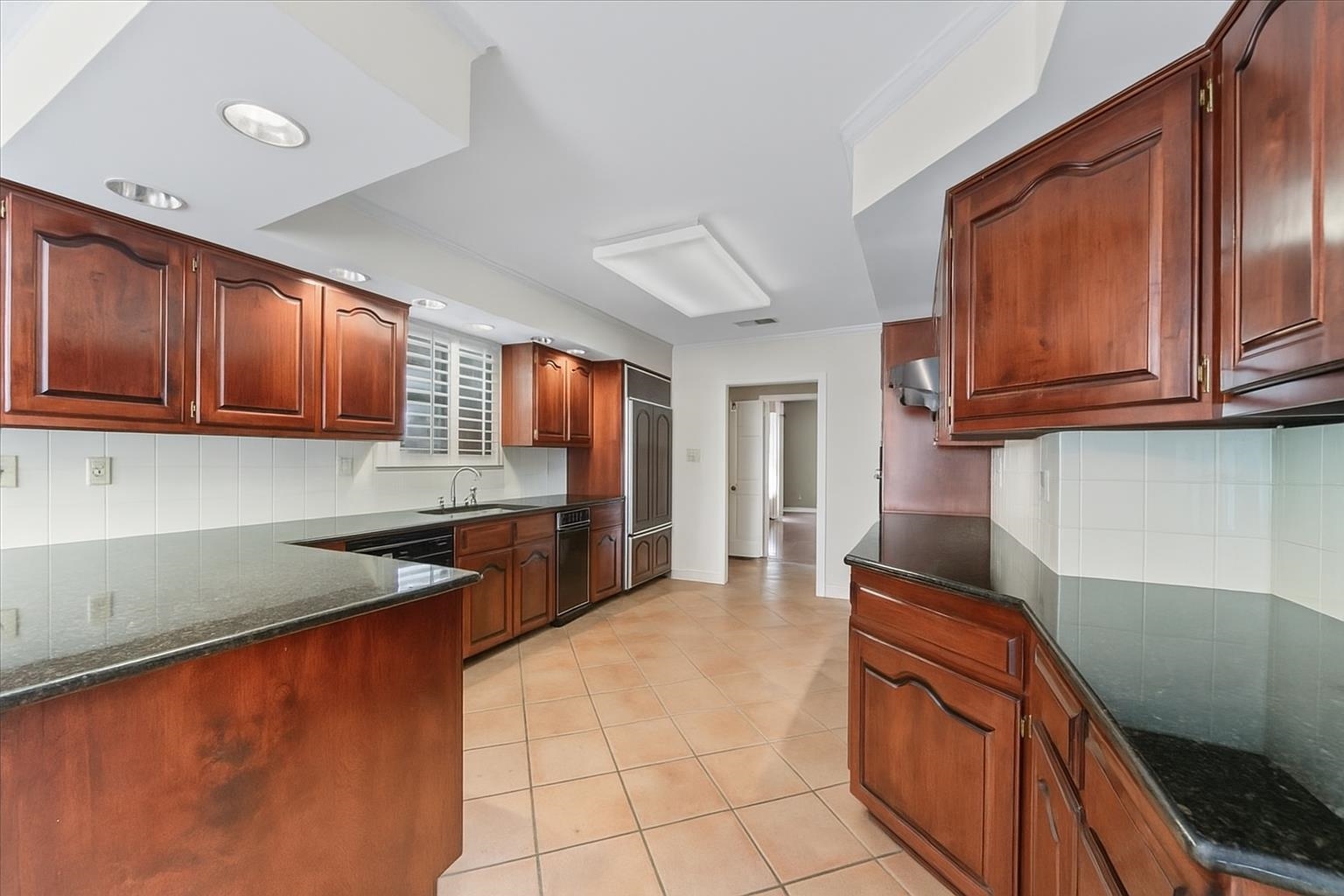 881 South Perkins Road Memphis, TN 38117 - Photo 11 of 33 Kitchen featuring decorative backsplash, light tile patterned floors, dark stone countertops, recessed lighting, and dishwasher
