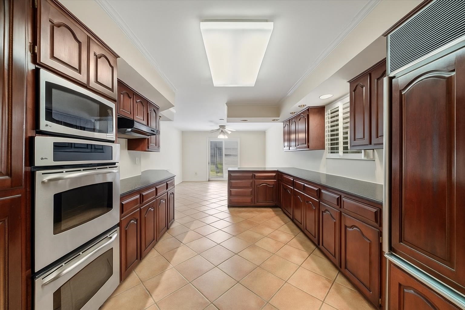 881 South Perkins Road Memphis, TN 38117 - Photo 12 of 33 Kitchen with stainless steel appliances, dark countertops, under cabinet range hood, a peninsula, and a ceiling fan