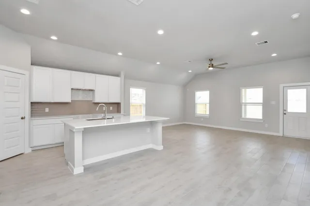 a view of a kitchen with a refrigerator and a sink