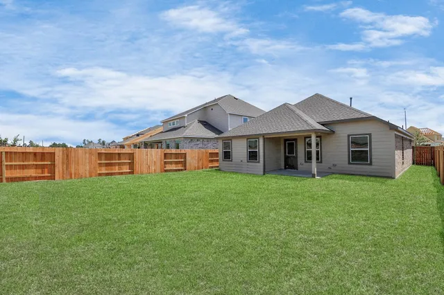 a view of a yard in front of a house with large trees