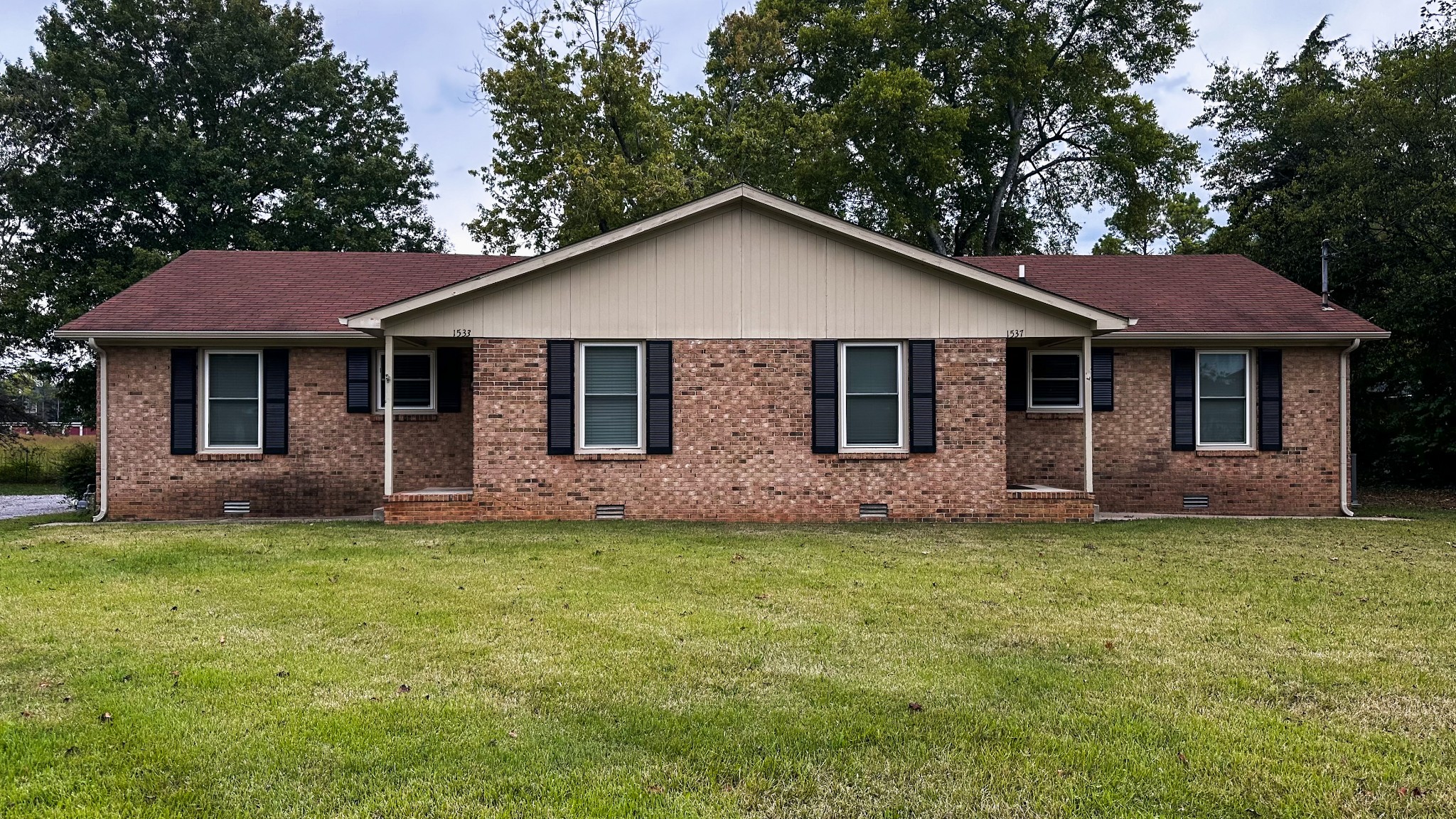 a front view of a house with a garden and yard