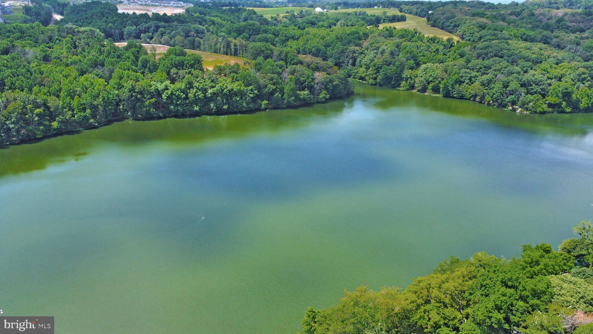 6705 West Lakeridge Road New Market, MD 21774 - Photo 19 of 39 a view of a lake with a yard