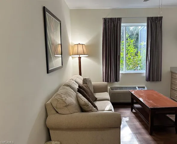 a living room with furniture a window and a flat screen tv