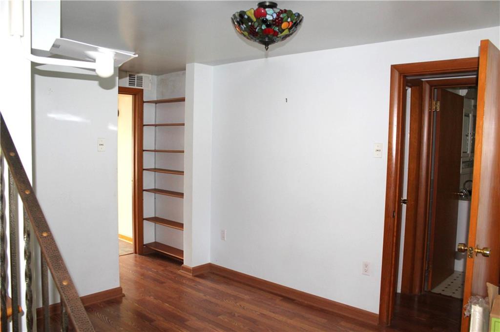 204 Ellsworth Street California, PA 15419 - Photo 11 of 27 an empty room with wooden floor and stairs